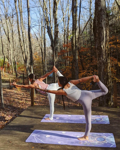 two women doing yoga in nature