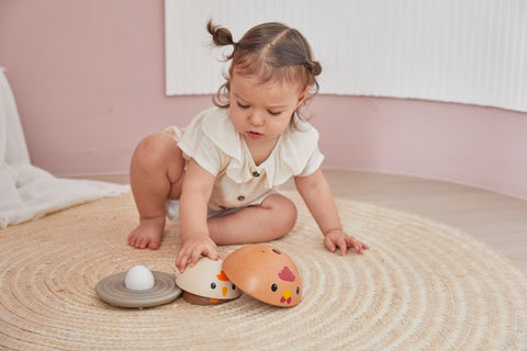 Child playing with a wooden chicken toy