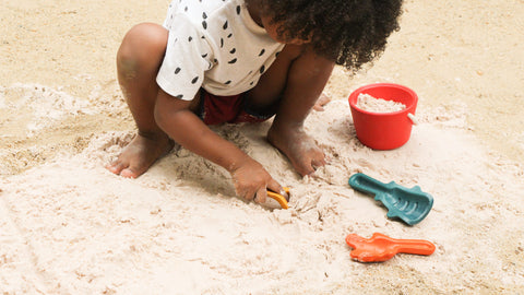 Child playing with sand tools at the beach