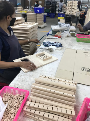 Wooden dollhouse parts being assembled in a factory