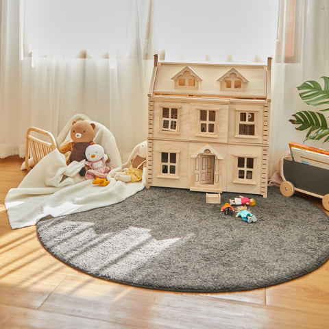 A victorian-style wooden dollhouse in a playroom