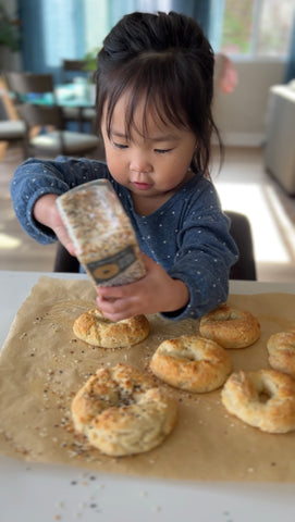 Child helping prepare homemade bagels