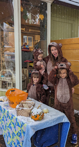 Family dressed as bears hosting a Halloween craft event outside a store