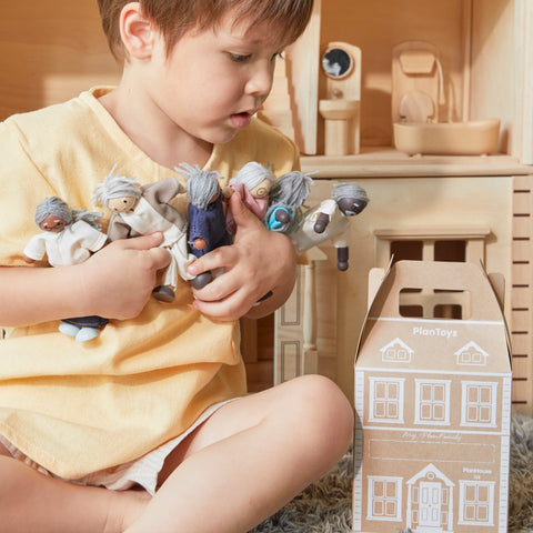 Child holding a group of doll figurines