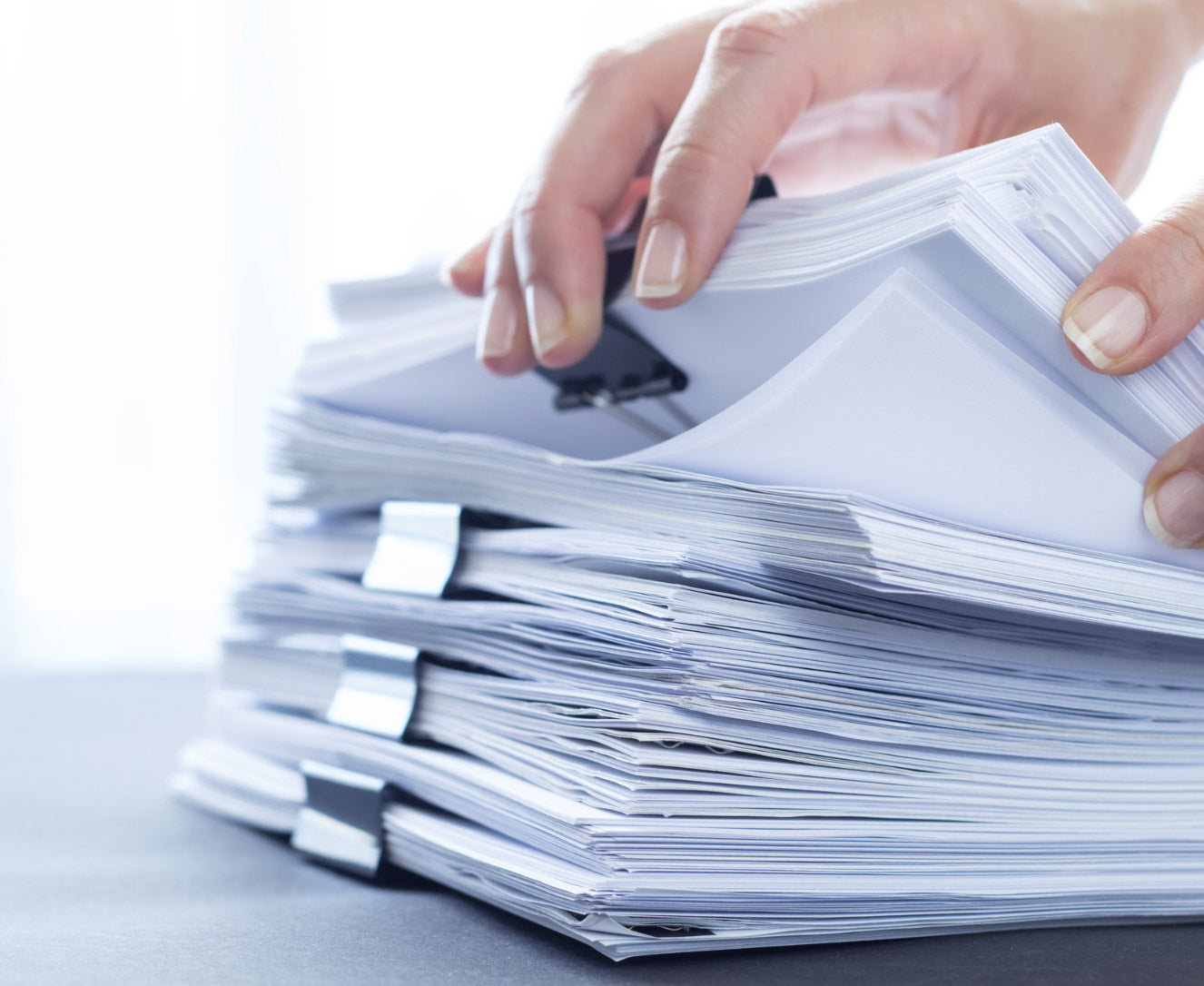 A stack of printed documents that are tracked by managed print services from BASE Technologies. 