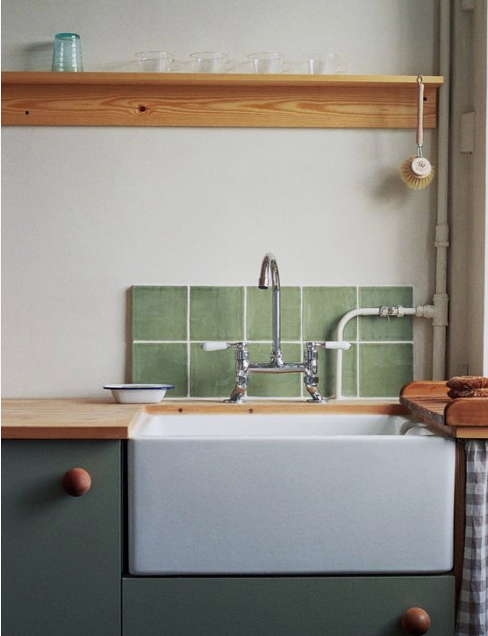 Small minimalist kitchen with green tiles backsplash.