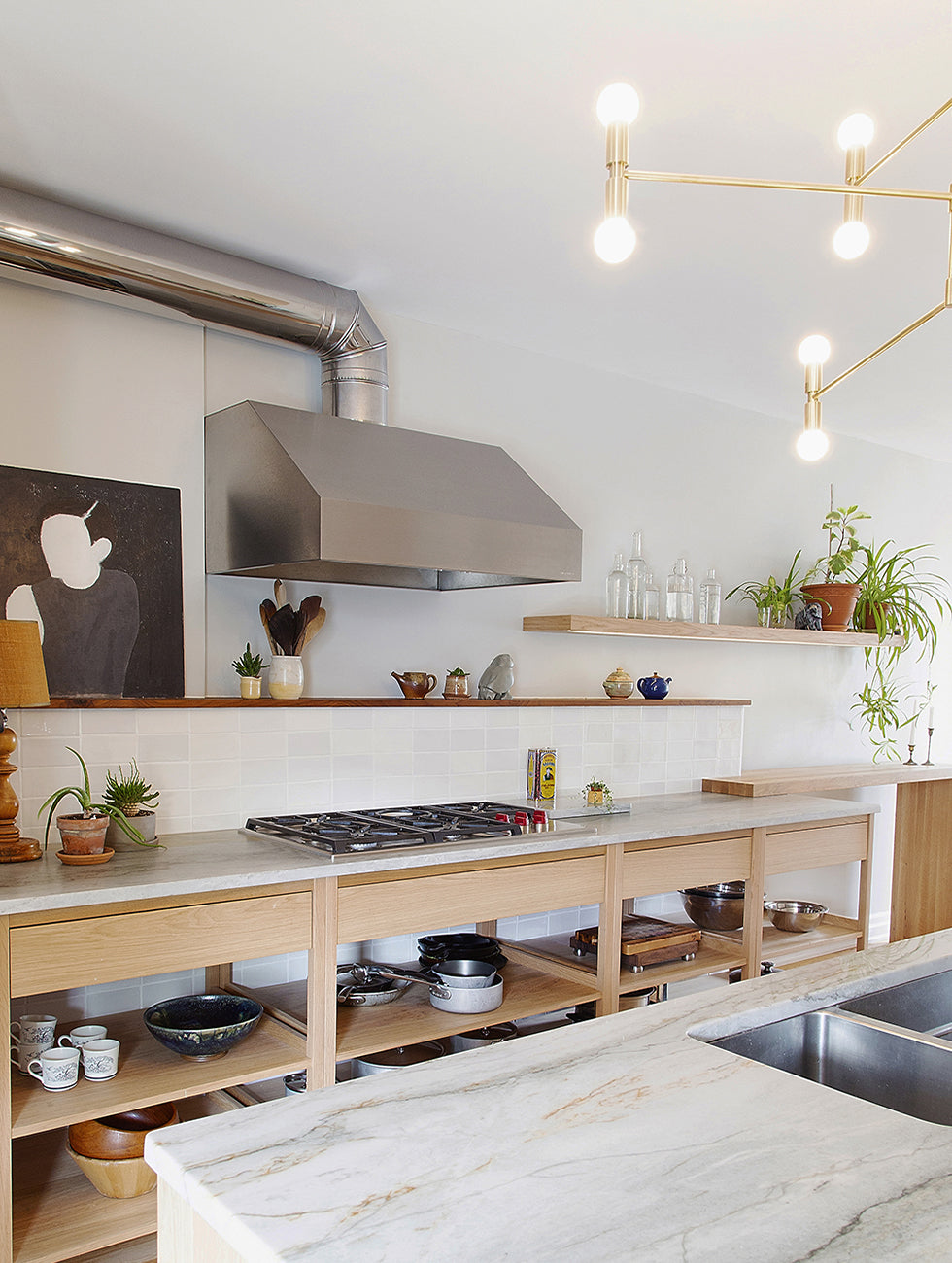 Scandinavian white oak kitchen with open cabinets in a bright open space. Mid-height backsplash in white tiles.