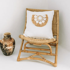 White coastal cushion with with raffia and shell detail. Coastal home