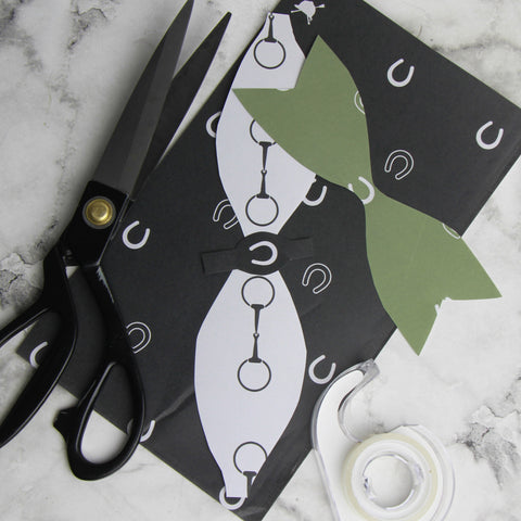 scraps of equestrian gift wrap cut out using our free downloadable DIY bow template