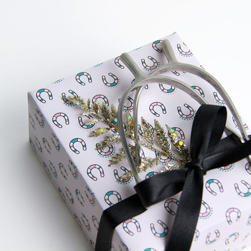 Equestrian chic gift wrapping ideas, attach a set of spurs to a gift with lucky horse shoe gift wrap.