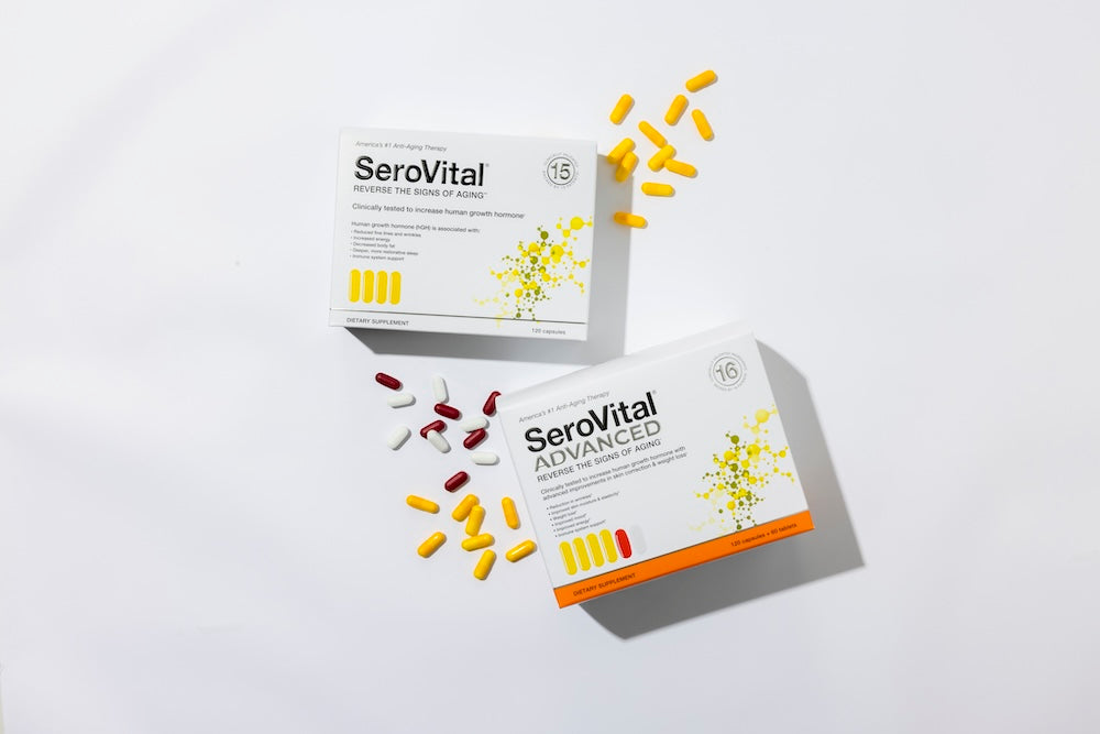 A box of HGH-boosting SeroVital with yellow capsules scattered next to it on a white background, along with a box of SeroVital ADVANCED with yellow capsules, plus red and white tablets scattered next to it
