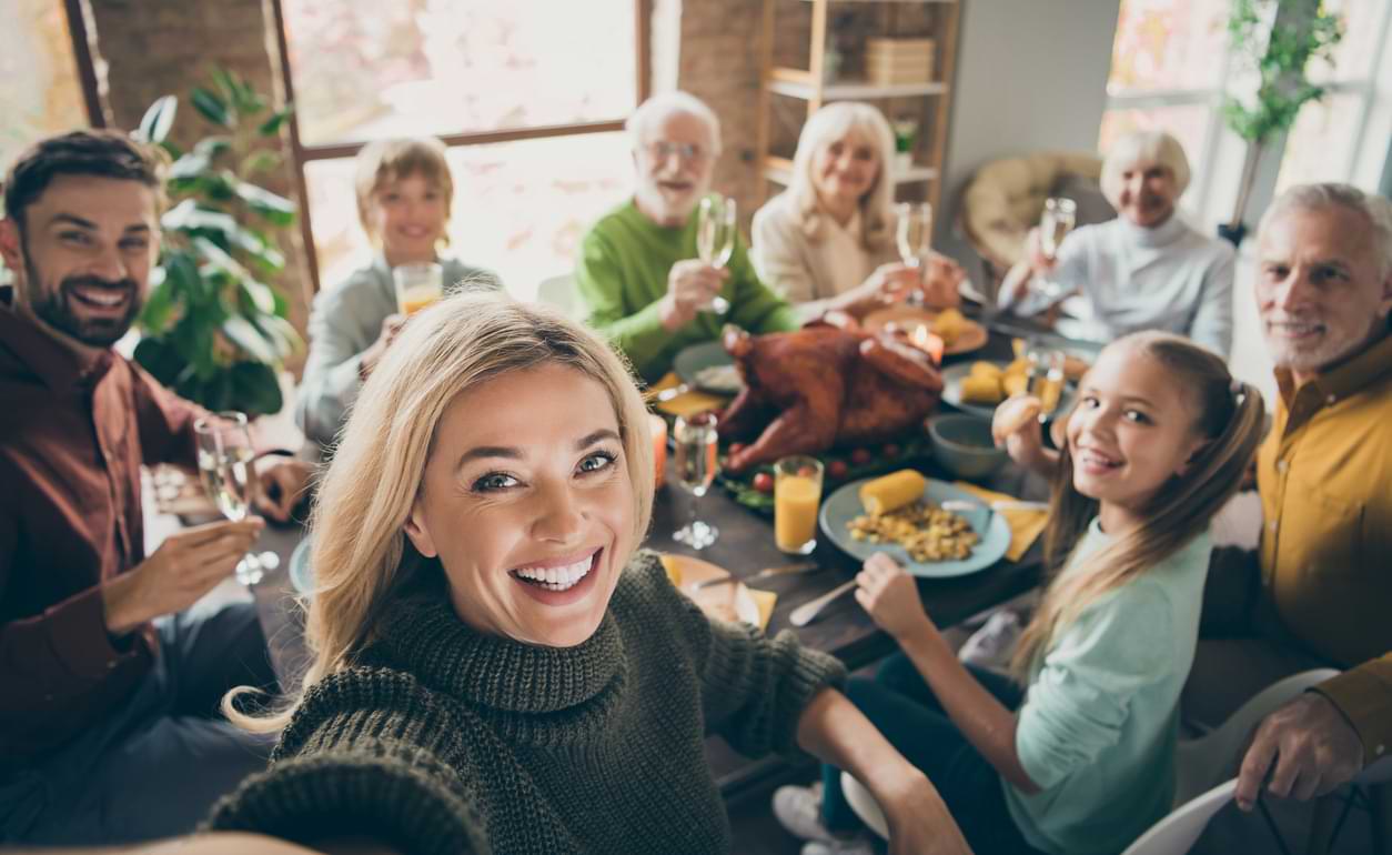 An extended family gathers together at the dinner table.