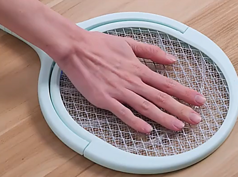 electric swatter with hand on it not getting shocked