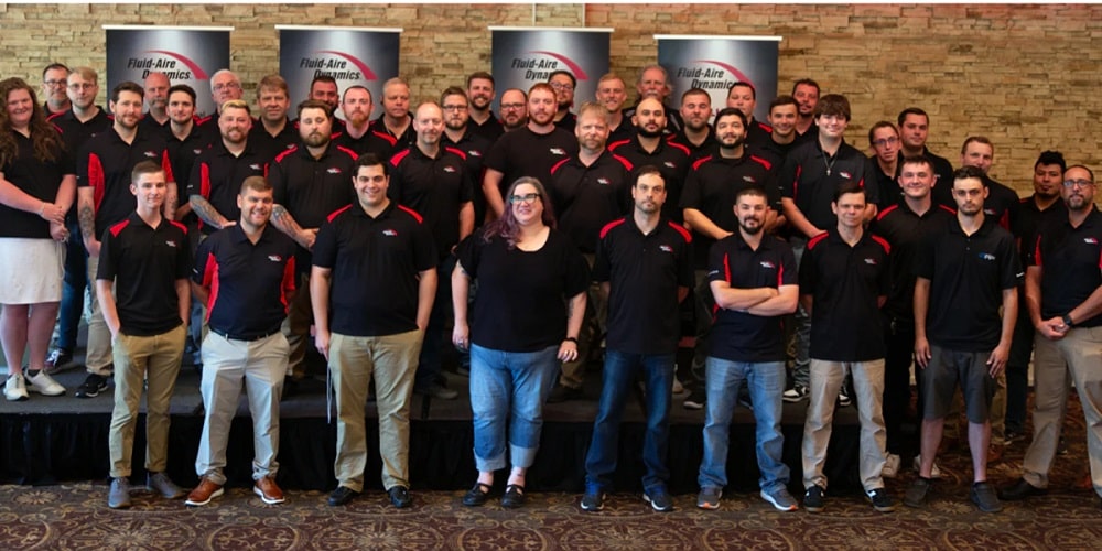 The air compressor service team from Fluid-Air Dynamics. A large group of maintenance technicians wearing black and read Fluid-Aire Dynamics shirts