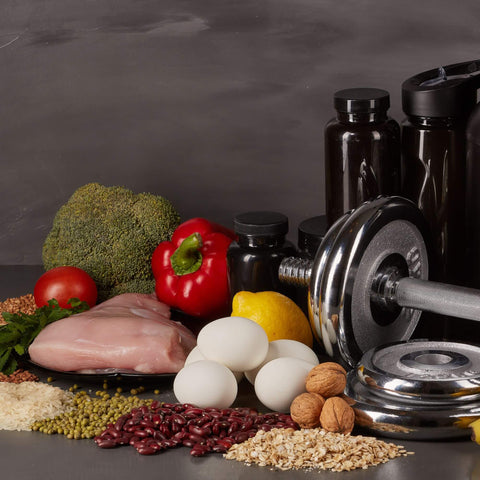 Bild welches Hanteln, Gewichte, Supplemente und gesunde Ernährung zeigt als Überleitung zum Thema Ernährung für den Muskelaufbau