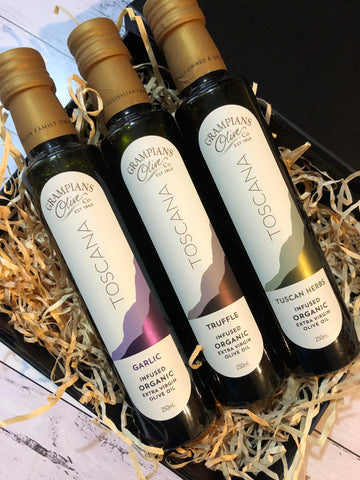 Three bottles of infused olive oil inside a black gift box