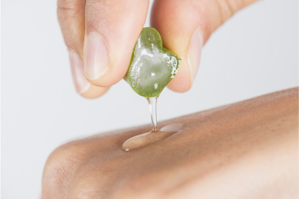 Person squeezing aloe vera gel onto hand