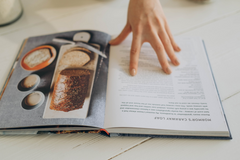 person reading open cookbook