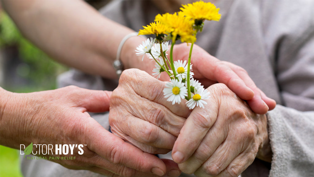 closeup photo of elderly women holding bouquet of yellow and white flowers