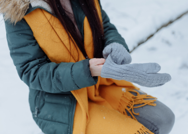 Woman putting on a winter glove