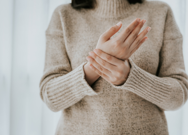 Woman wearing sweater holding hands