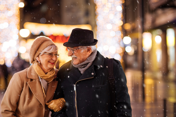 Elderly couple outside smiling at Christmastime