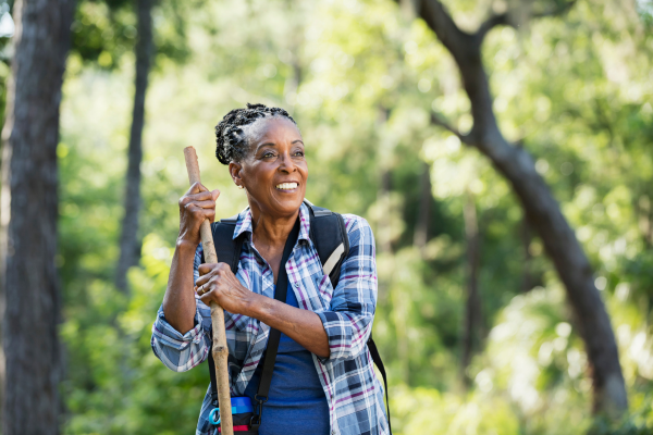 Elderly woman hiking and holding a walking stick