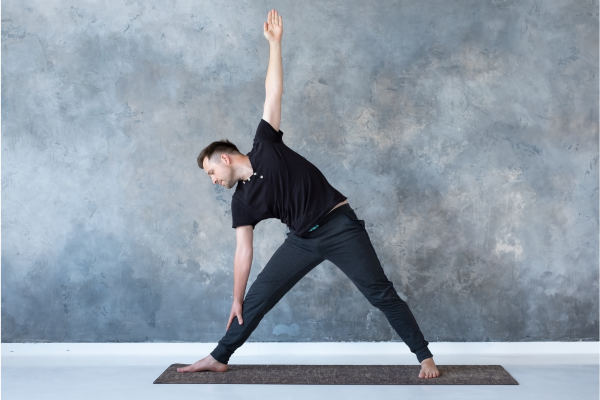 Man standing on mat doing yoga
