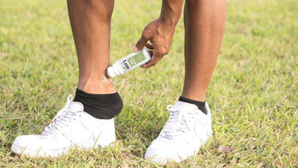 Man using Doctor Hoy’s Pain Relief Roll-On Gel to stop ankle pain