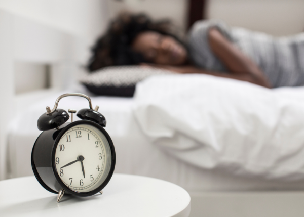 Person sleeping in background and a clock