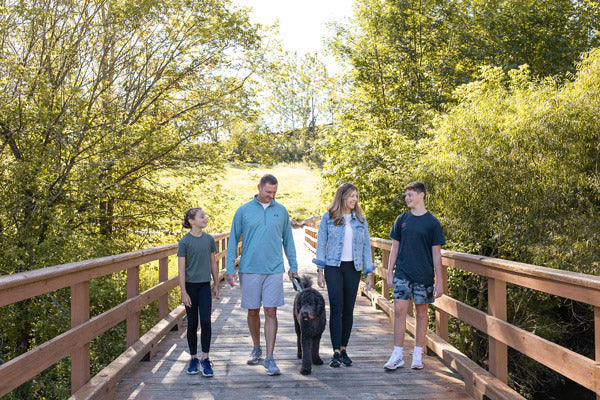 A family and a dog outside on a walk