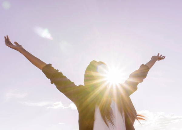 Woman enjoying the sunshine and spreading her arms