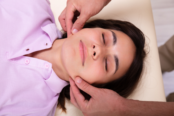 Woman having her jaw massaged