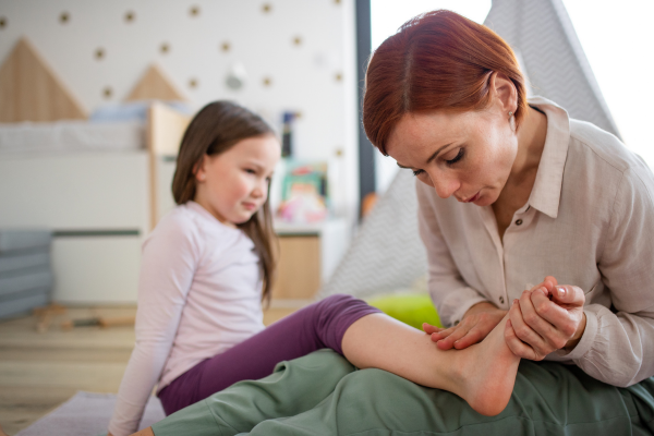 mother tending to her daughter's ankle injury