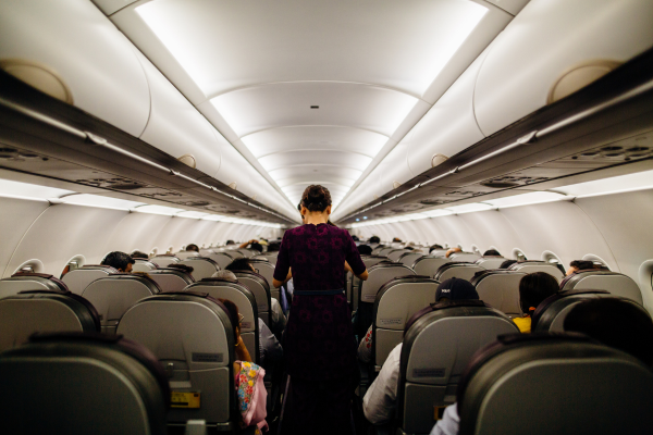 People walking in aisle of airplane