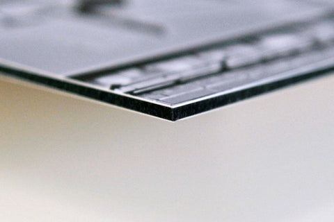 Seitenansicht von einem Alu-Dibond Bild, wo man die Aluminium Platten und den Polyethylenkern sieht.
