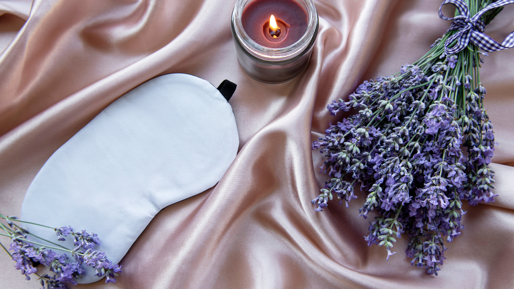 A sleep mask, lavender, and a candle
