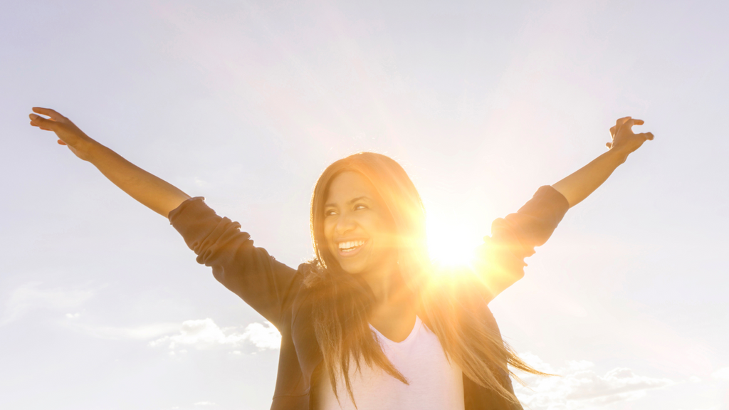 Happy woman standing in the sun