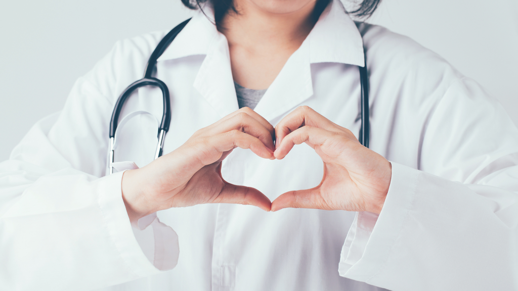 Doctor making a heart shape with her hands at the camera