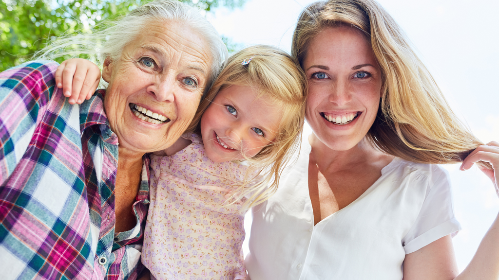 Three generations of women smiling together for a picture