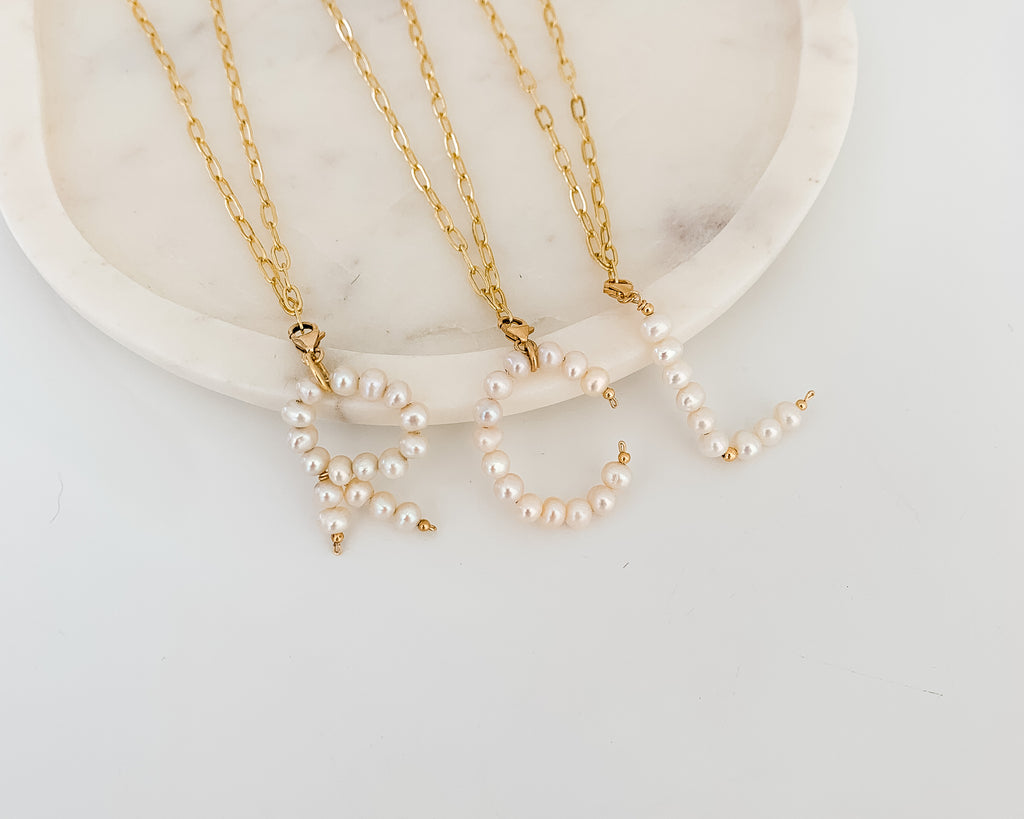 Three freshwater pearl pendant necklaces.  The pendants are crafted with tiny freshwater pearls strung on heavy gauge 14k gold filled wire.  The letters R, C, and L are shown suspended from simple gold chain necklaces.  