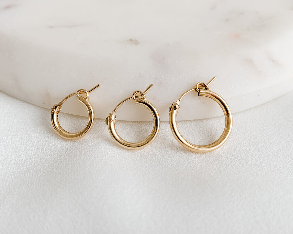 Classic tube hoop earrings in 14k gold filled shown in three sizes.  