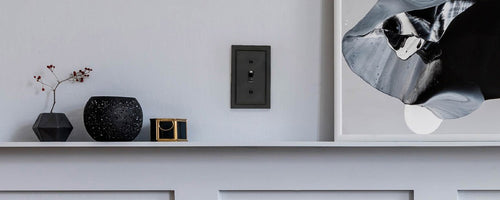 A photo of the Bethany black metal wallplate on a gray wall