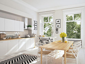 An interior photo of a professionally designed Scandinavian decor style kitchen with an open concept, and light wood dining table, open windows, yellow flowers, and a decorative black and white striped rug