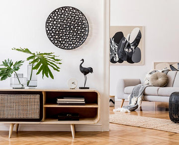 An interior photo of a professionally designed Scandinavian decor style living room with an open floor plan, hardwood floors, abstract wall art, and sleek Scandinavian style furniture