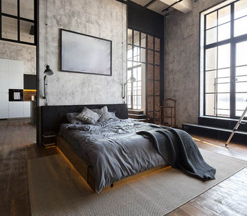 An interior photo of a professionally designed Industrial decor style bedroom with cement walls, large windows, black metal accents, with an open concept style