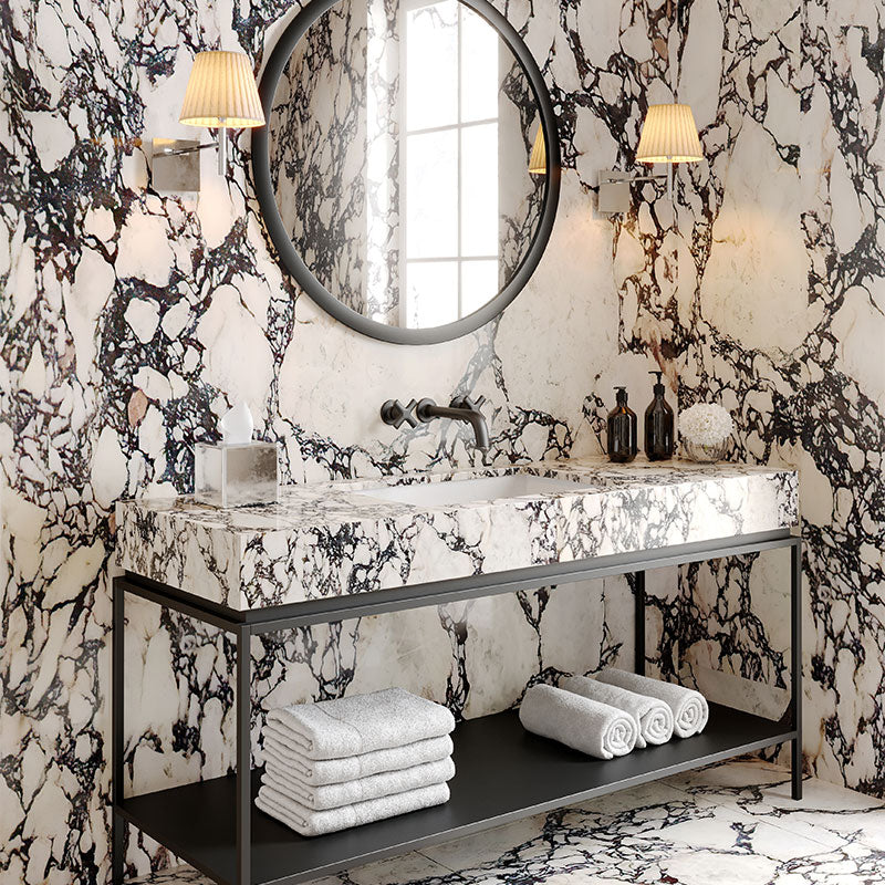 A professionally designed California Casual decor style bathroom with marble countertops and walls, and black metal furniture and hardware