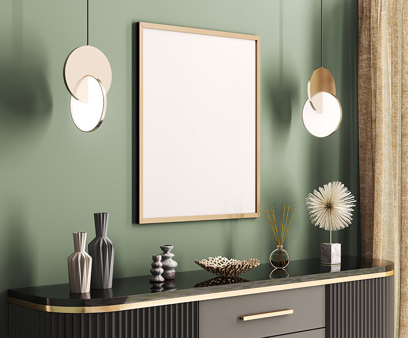 An Art Deco decor style room with a sideboard with a glossy black top and gold hardware, green walls, a gold picture frame, and various Art Deco style decorations