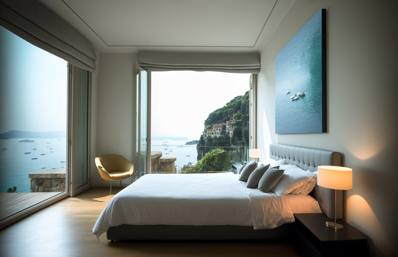 A Mediterranean decor style bedroom with large windows that show the Mediterranean Sea in the background