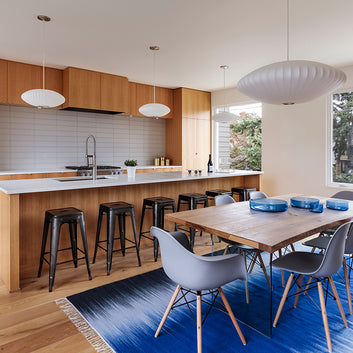 An interior photo of a professionally designed Mid-Century Modern decor style kitchen and dining table
